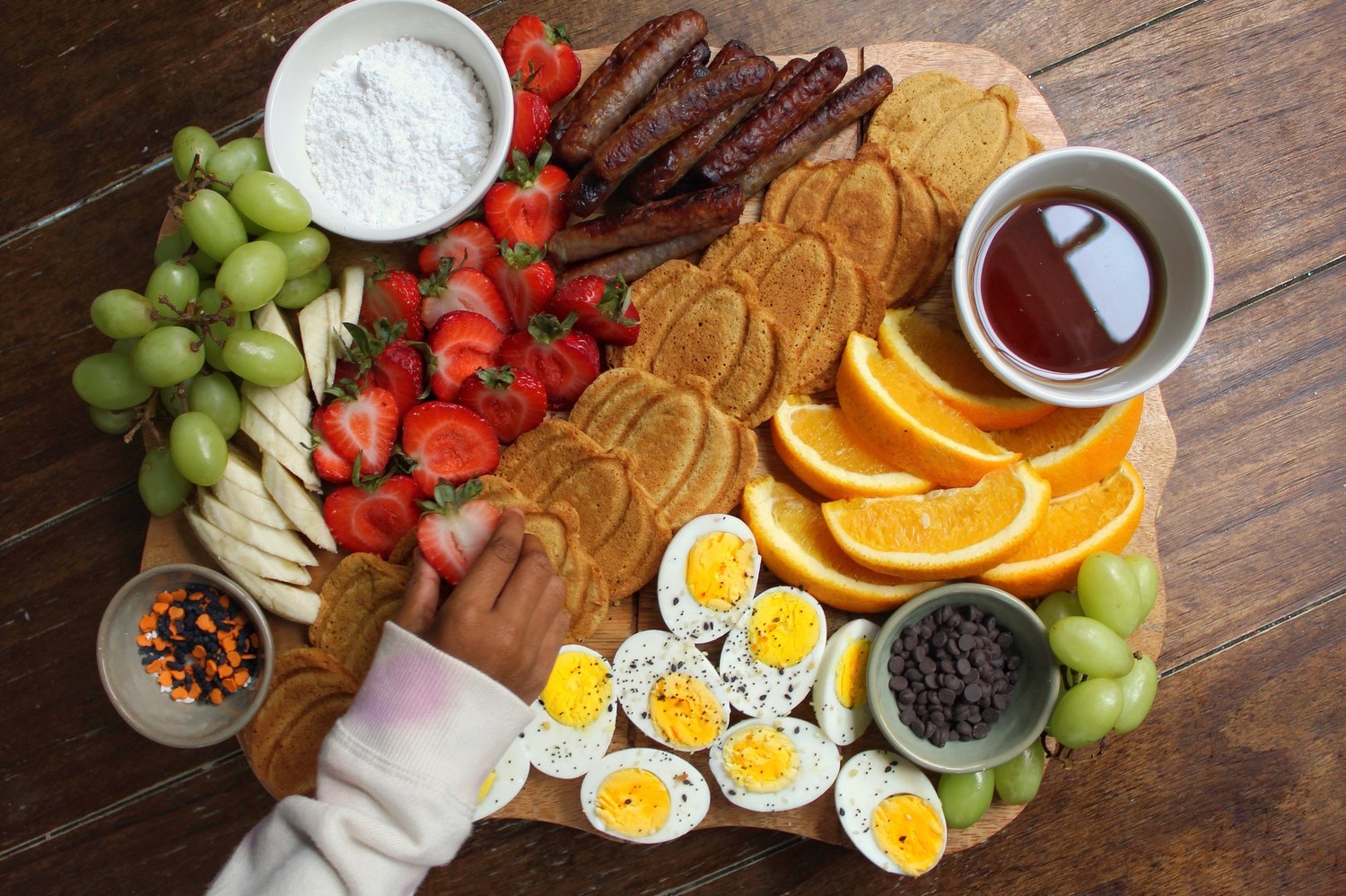 A perfect breakfast board with pumpkin pancakes, fruits, breakfast meats, dips, and Pete and Gerry's Organic Eggs.