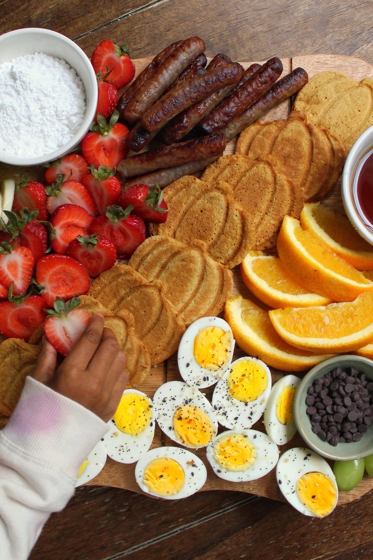 A perfect breakfast board with pumpkin pancakes, fruits, breakfast meats, dips, and Pete and Gerry's Organic Eggs.