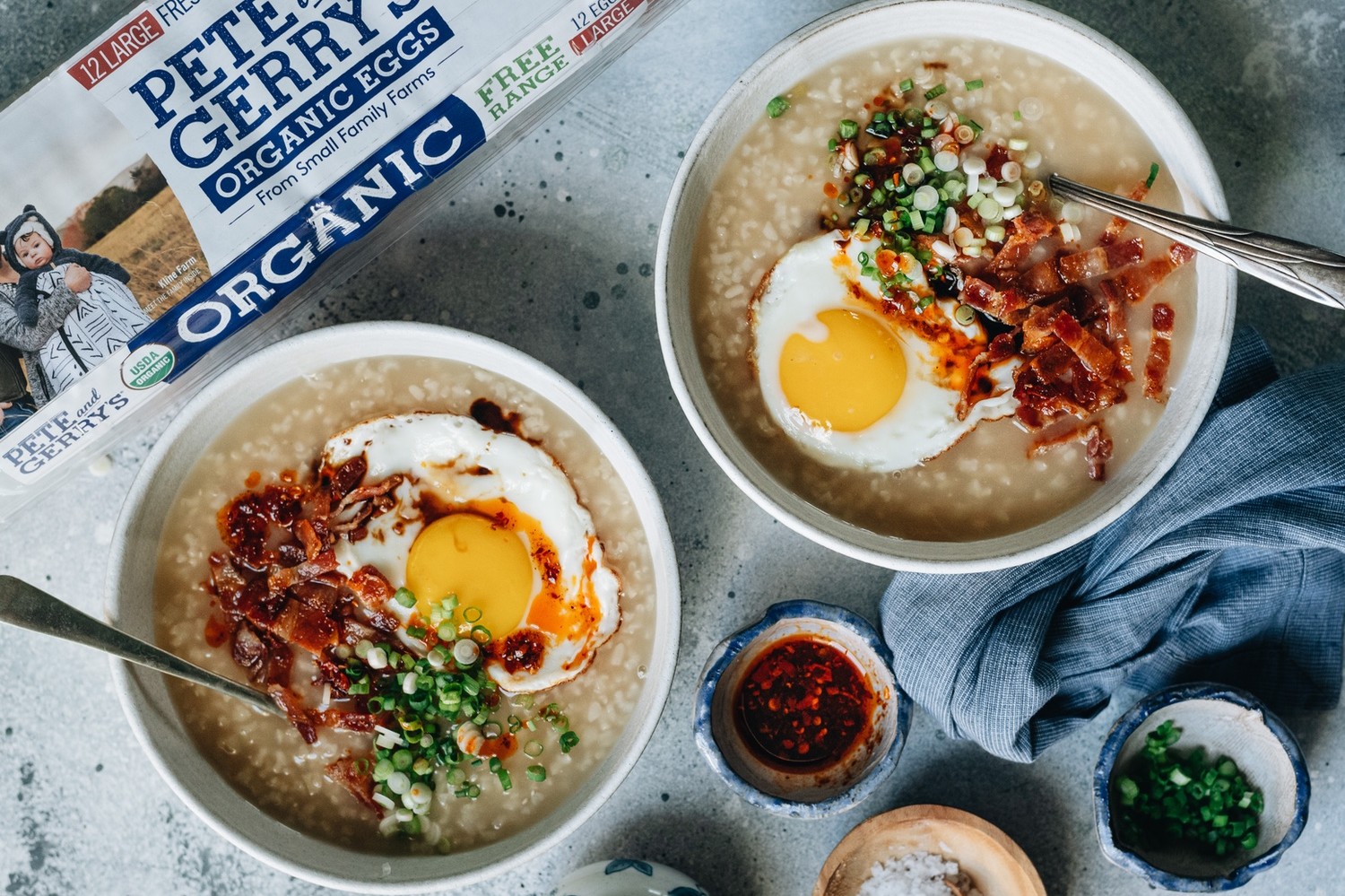 An easy Instant Pot recipe for reliably sticky breakfast congee topped with crispy bacon, fried eggs, and chili oil. | peteandgerrys.com