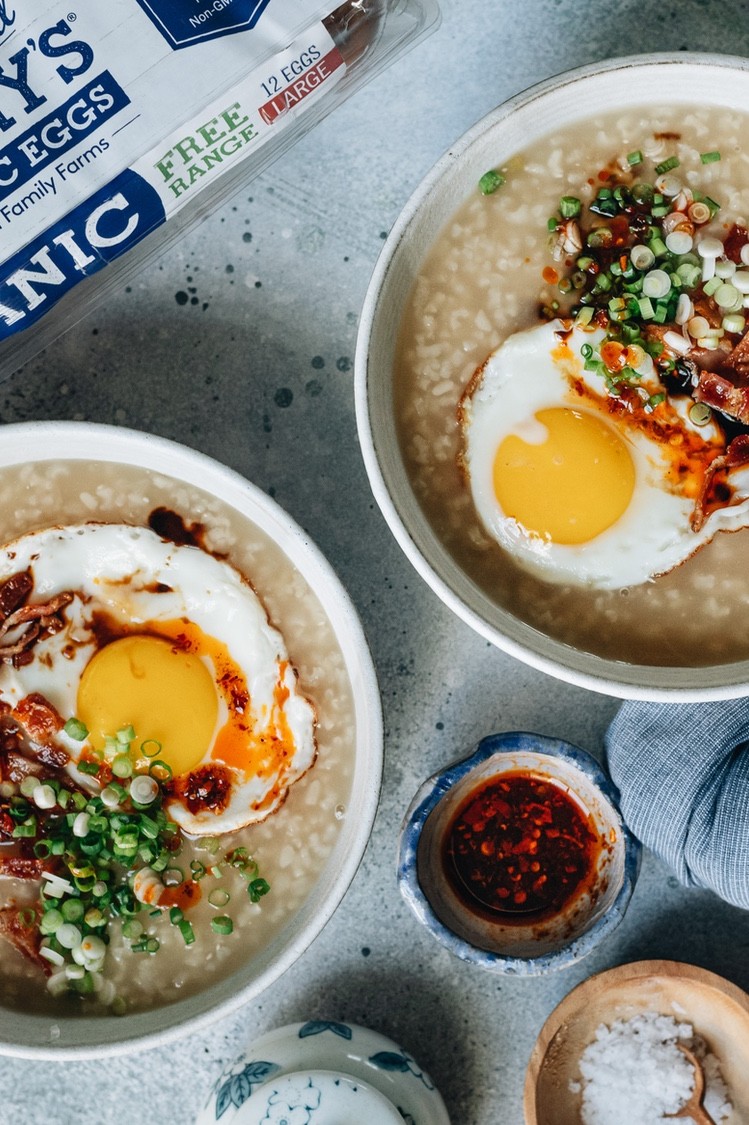 An easy Instant Pot recipe for reliably sticky breakfast congee topped with crispy bacon, fried eggs, and chili oil. | peteandgerrys.com