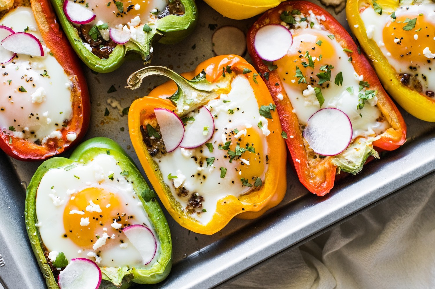 Red, yellow, and green bell peppers stuffed with a mixture of onions, mushrooms, and Mexican chorizo. Topped with an organic, free range egg and baked. | peteandgerrys.com 