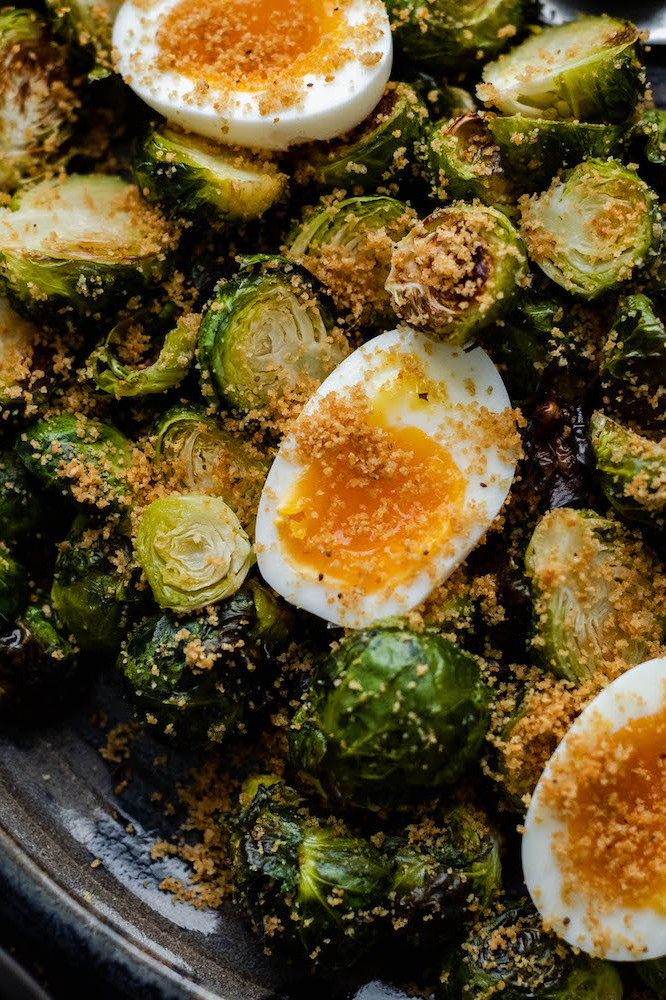 This simple side-dish is made by mixing roasted brussel sprouts, garlic, breadcrumbs, and olive oil together. The dish features jammy organic hard-boiled eggs. | peteandgerrys.com 