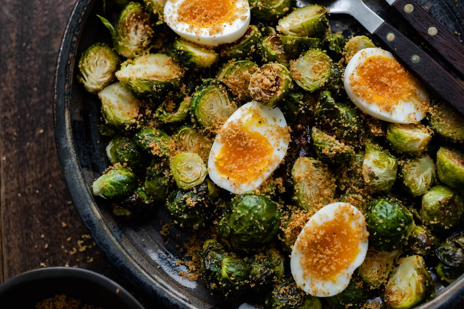 This simple side-dish is made by mixing roasted brussel sprouts, garlic, breadcrumbs, and olive oil together. The dish features jammy organic hard-boiled eggs. | peteandgerrys.com 