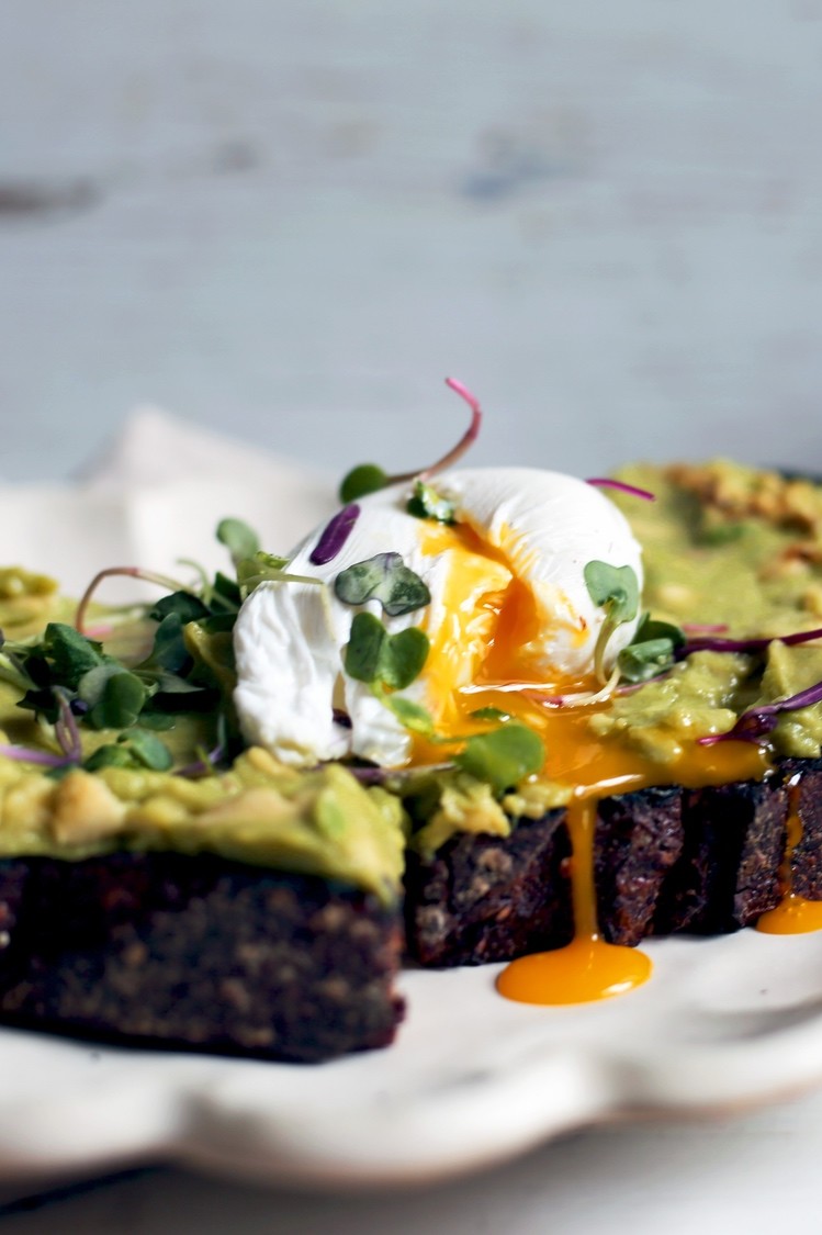 Toasted slice of sourdough bread topped with mashed avocado, microgreens, a runny poached organic egg, and a drizzle of CBD-infused coconut oil. | peteandgerrys.com 