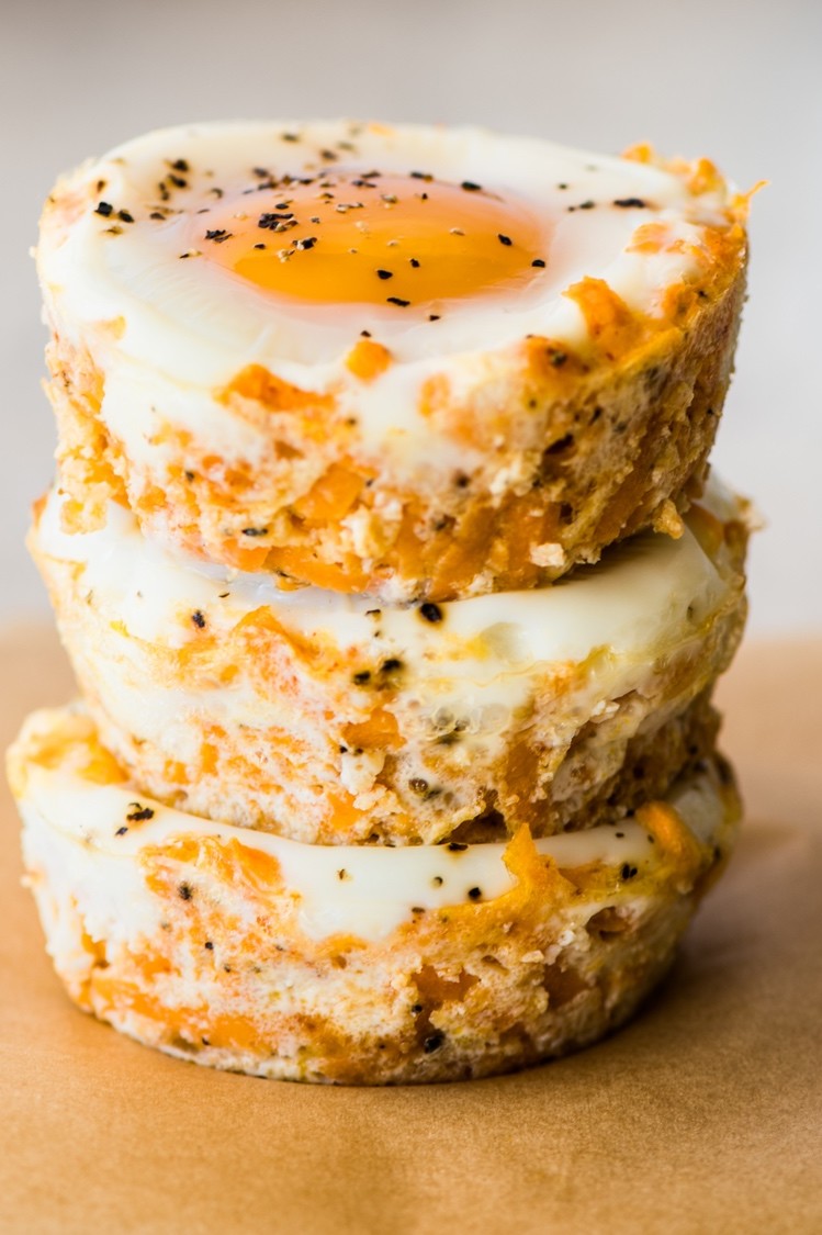 Chipotle sweet potato egg cups baked in a muffin tin. Stack of three egg cups shows layers of shredded sweet potato, cheese, chipotle powder, and eggs. | peteandgerrys.com 