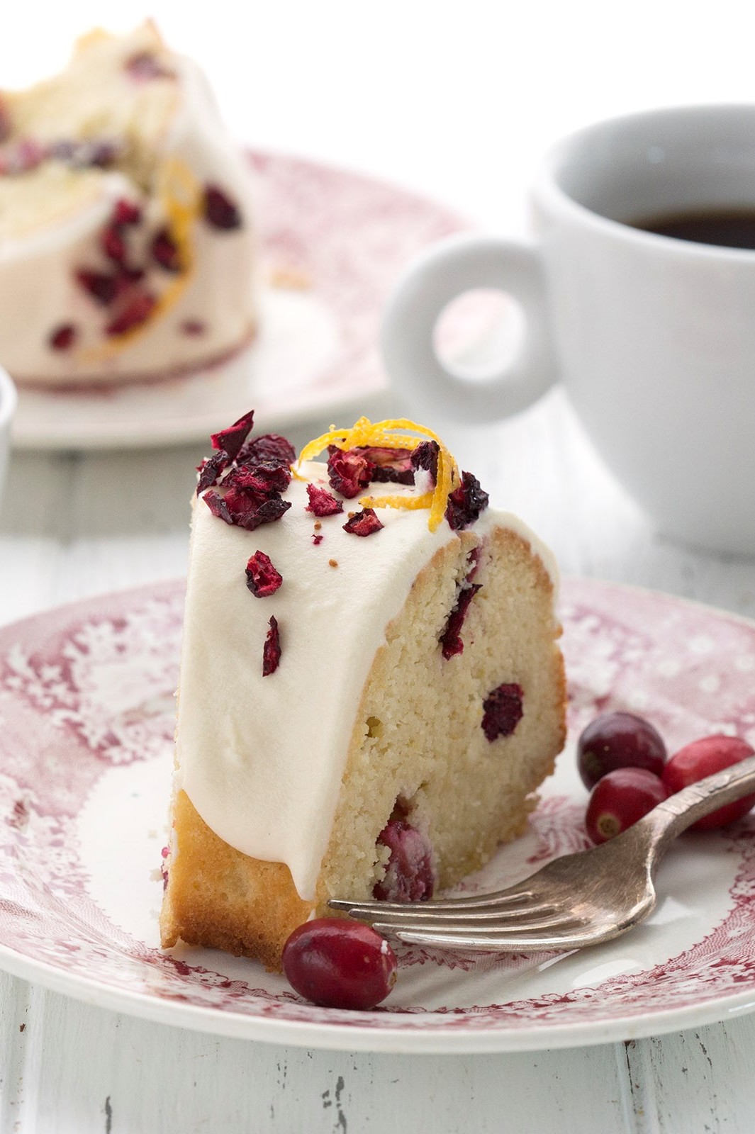 This beautiful, gluten-free, keto, cranberry bliss pound cake is perfect for the holidays. It features a moist interior with hints of cranberry and orange zest. The cake is topped with a cream cheese glaze. And served with hot coffee. | peteandgerrys.com