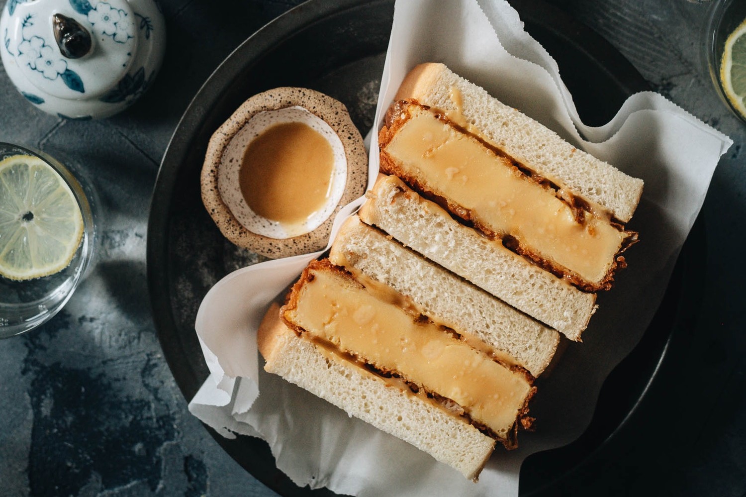 A Dominique Ansel copycat recipe for Shake Shack's limited edition egg katsu sandwich. Cross section highlights panko-crusted egg patty between slices of milk bread slathered with miso honey mayonnaise. | peteandgerrys.com