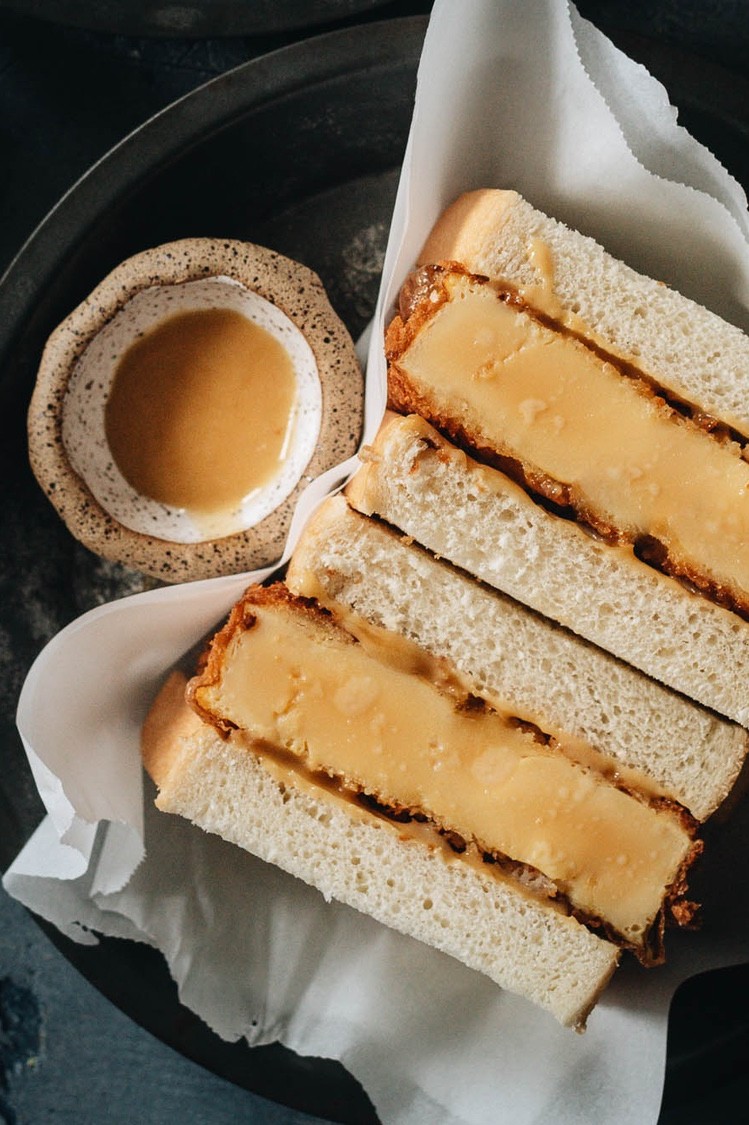 A Dominique Ansel copycat recipe for Shake Shack's limited edition egg katsu sandwich. Cross section highlights panko-crusted egg patty between slices of milk bread slathered with miso honey mayonnaise. | peteandgerrys.com