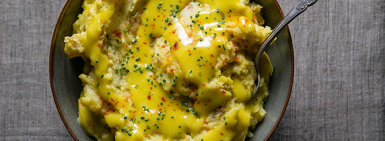 Thee delicious yukon-gold potatoes are mashed with olive oil, chives, and fresh bay leaves. The potatoes are topped with a golden aïoli made with organic eggs. | peteandgerrys.com 