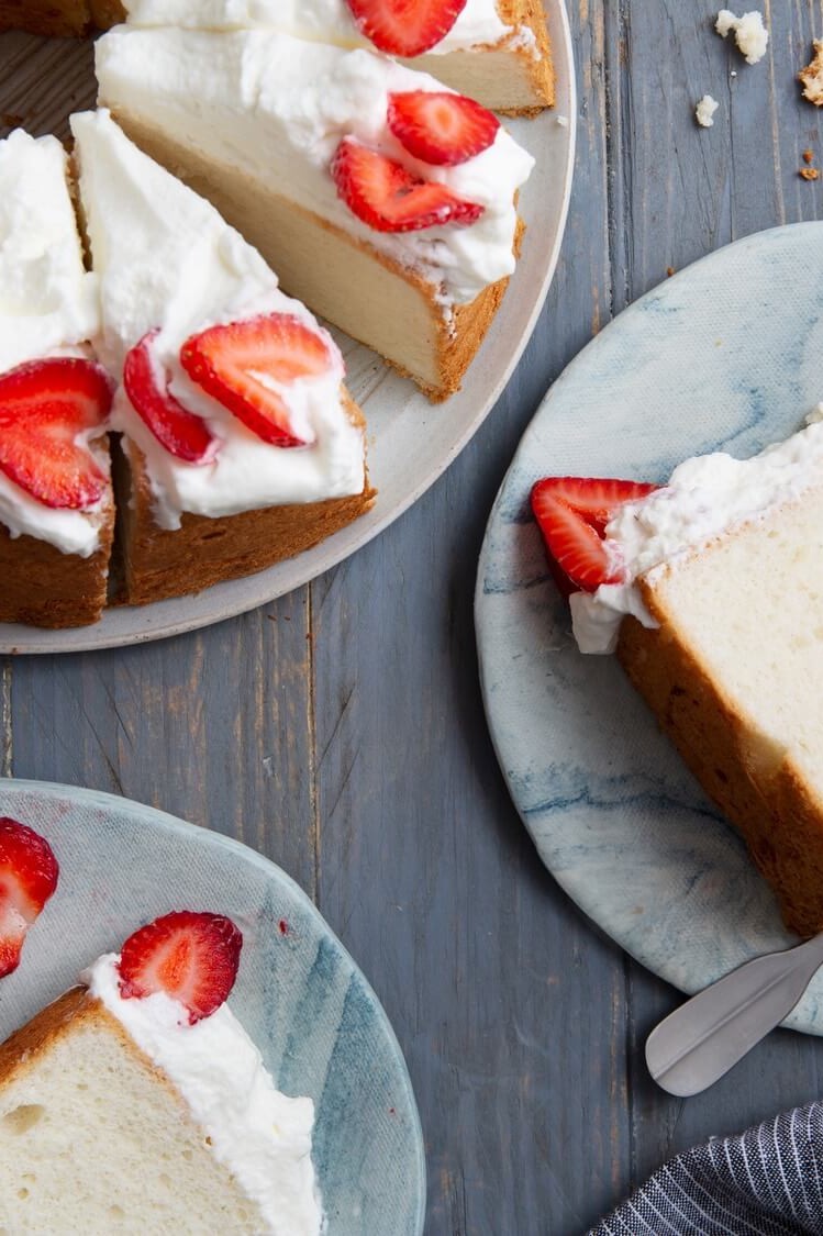 An airy, delightful angel food cake with a light crumb. Made with just seven ingredients and topped with whipped cream and fresh strawberries. | peteandgerrys.com 