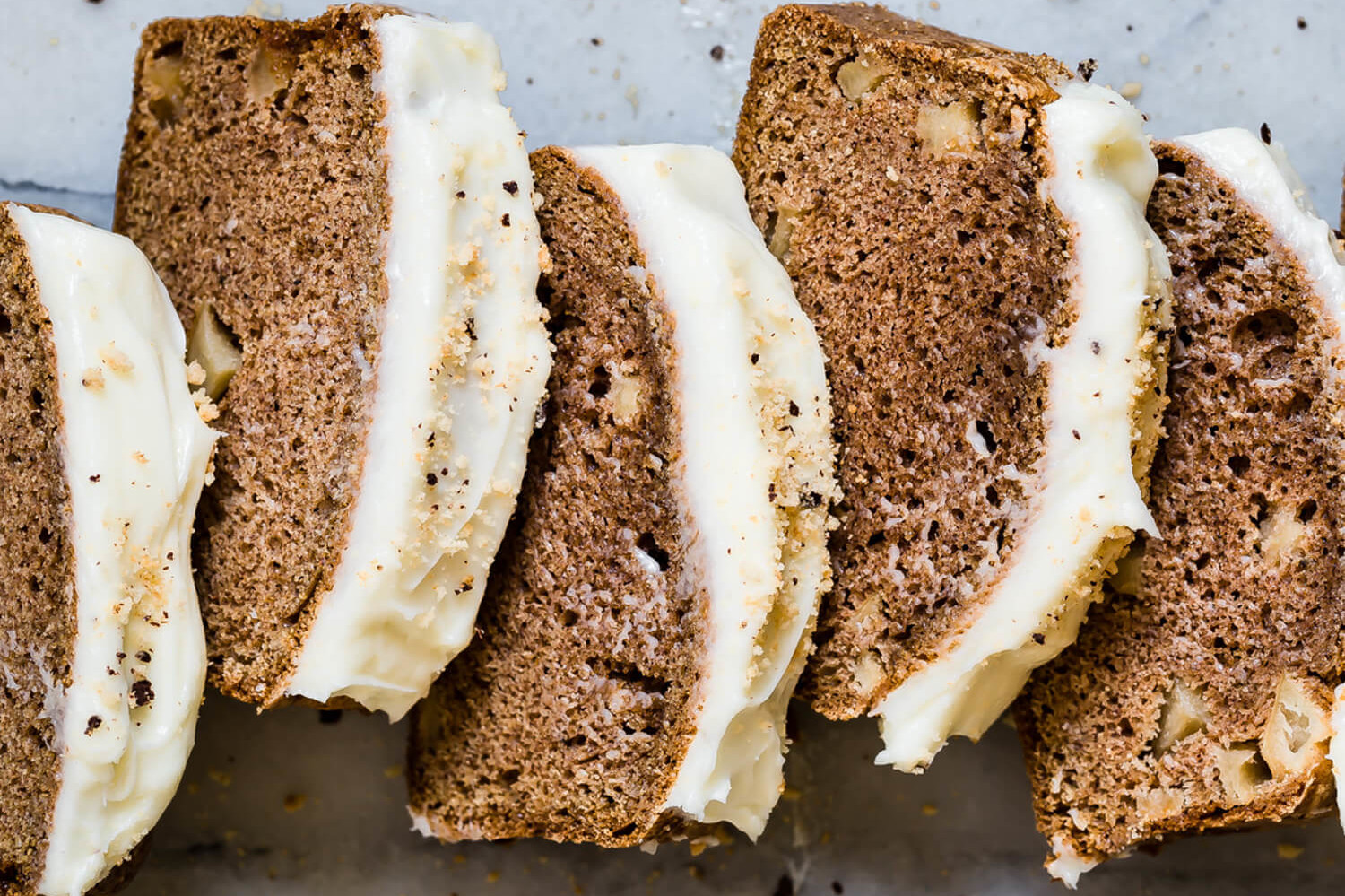 This spiced apple loaf features pieces of real apple, ground cinnamon, nutmeg, and cloves. The loaf is topped with an easy frosting made with confectionary sugar and cream cheese. | peteandgerrys.com 