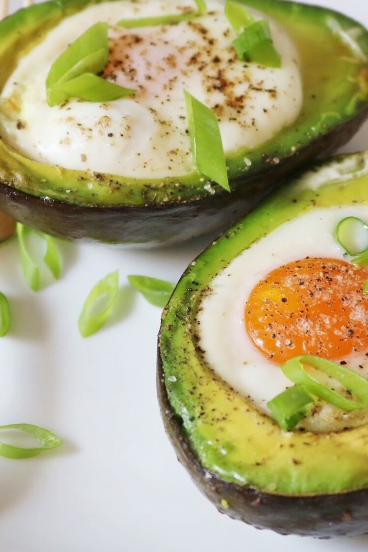 A recipe for avocado egg boats by dietitian Keri Glassman. Avocado is halved, and each half is filled with an organic egg and baked for a nutritious combination of protein and healthy fats. | peteandgerrys.com 