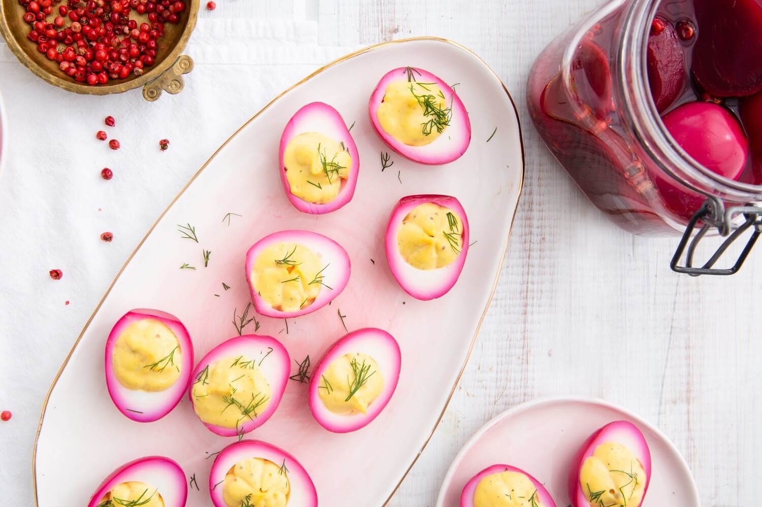 Beet pickled deviled eggs on platter. Hard-boiled eggs are soaked in beet juice overnight, resulting in a a violet exterior. Cross section shows vibrant yellow yolk filling piped into each deviled egg half. | peteandgerrys.com   