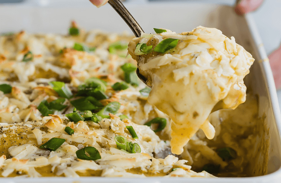 These breakfast enchiladas are made with a green verde sauce, grated white cheddar cheese, crispy hash browns, and topped with green onions. | peteandgerrys.com 