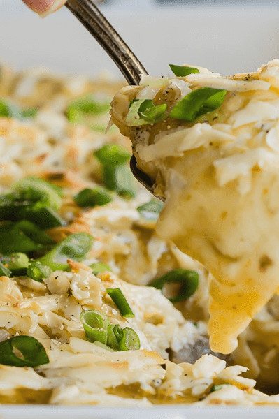 These breakfast enchiladas are made with a green verde sauce, grated white cheddar cheese, crispy hash browns, and topped with green onions. | peteandgerrys.com 