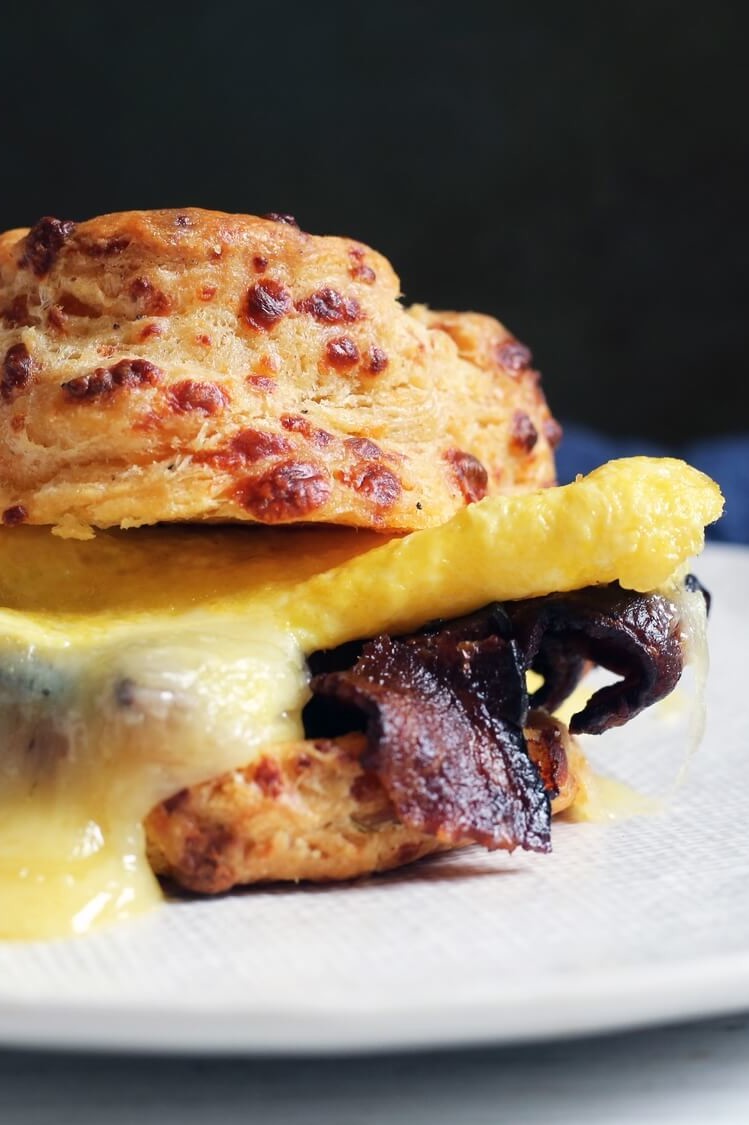 Breakfast sandwich with homemade cheddar cheese biscuits, crispy bacon, folded eggs, and more cheese. | peteandgerrys.com 