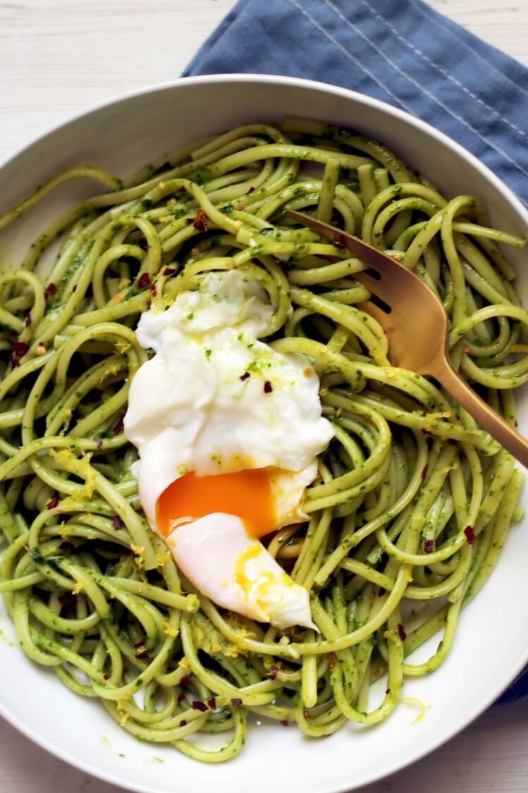 Bowl of spaghetti coated in homemade CBD-infused pesto. Topped with a poached egg, which has been cut open to allow the deeply golden yolk to flow into the pasta. | peteandgerrys.com 