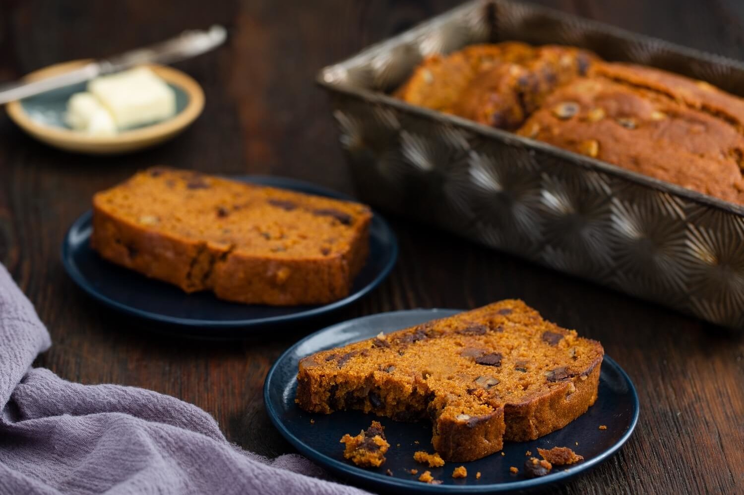 Pumpkin spice quick bread with seasonal autumn flavors. Slices show a moist crumb, rich orange color, and a generous amount of chocolate chips and nuts sprinkled throughout every bite. | peteandgerrys.com 