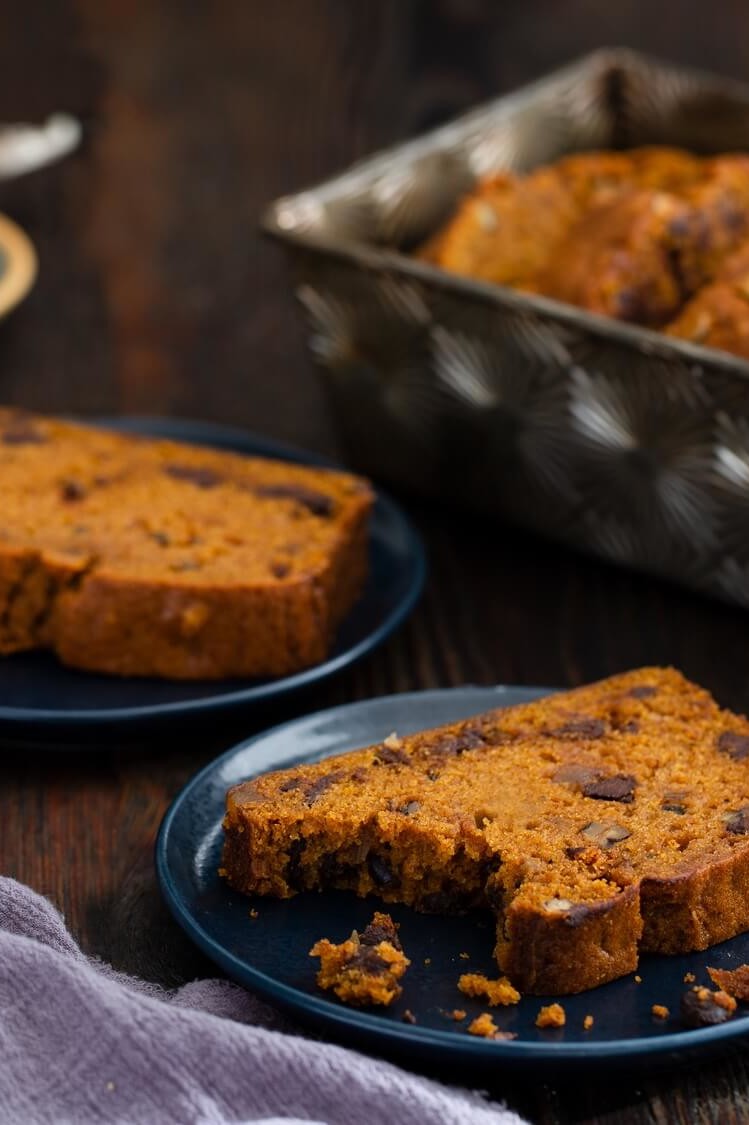 Pumpkin spice quick bread with seasonal autumn flavors. Slices show a moist crumb, rich orange color, and a generous amount of chocolate chips and nuts sprinkled throughout every bite. | peteandgerrys.com 