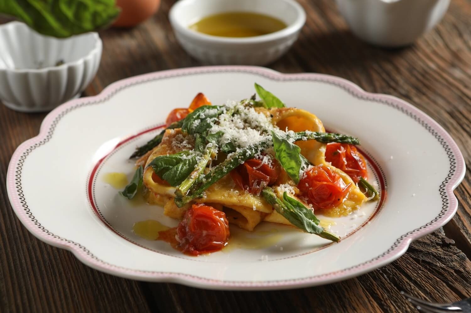 This gluten-free dish features homemade egg ribbon pasta, roasted asparagus, and blistered cherry tomatoes topped with Parmesan cheese. | peteandgerrys.com 