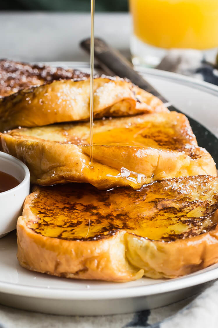 Golden brown eggnog French toast drizzled with maple syrup and dusted with powdered sugar. | peteandgerrys.com 