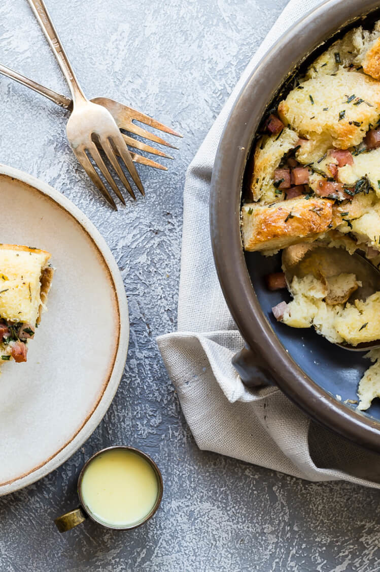 This eggs benedict bread pudding is generously filled with fresh sourdough bread, Canadian ham, parmesan cheese, fresh chives, and fresh rosemary. | peteandgerrys.com 