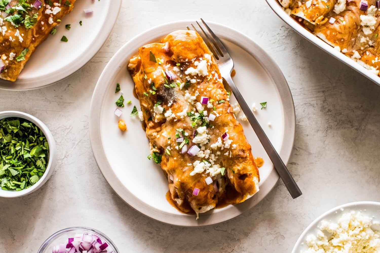 Breakfast enchiladas made with flour tortillas and stuffed with peppers, crumbled sausage, scrambled eggs, Southwest spices, and cheese. Topped with red enchilada sauce. | peteandgerrys.com 