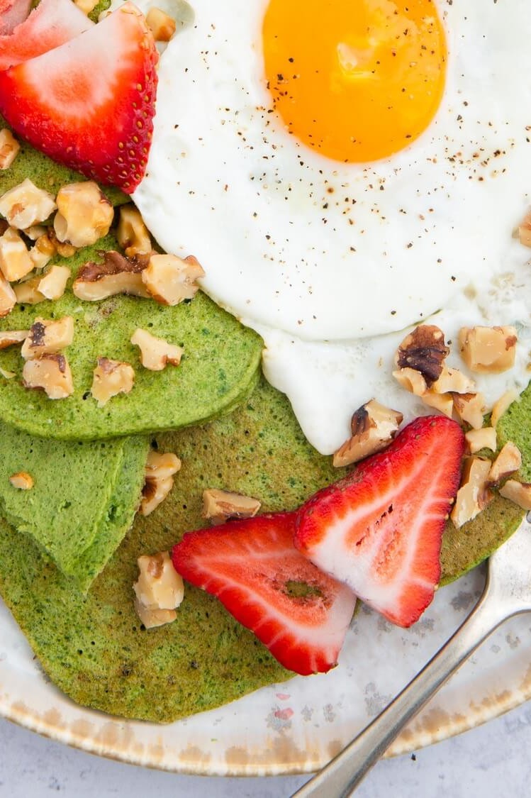 This green pancakes recipe features pancakes based with spinach and bananas. Our pancakes are topped with sliced strawberries, walnuts, and a fried egg. | peteandgerrys.com 