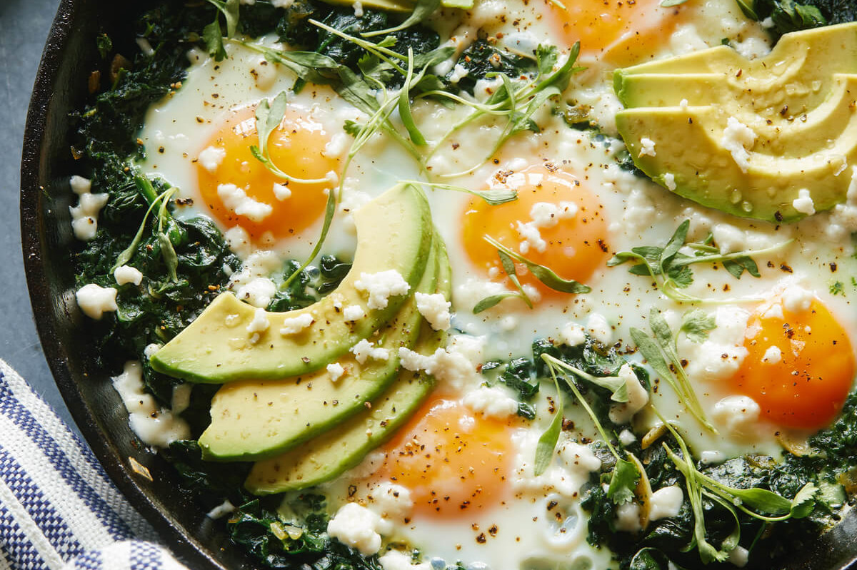 This hearty and delicious green shakshuka features fresh green spinach, avocados, queso fresco, cilantro, and runny organic eggs. | peteandgerrys.com 