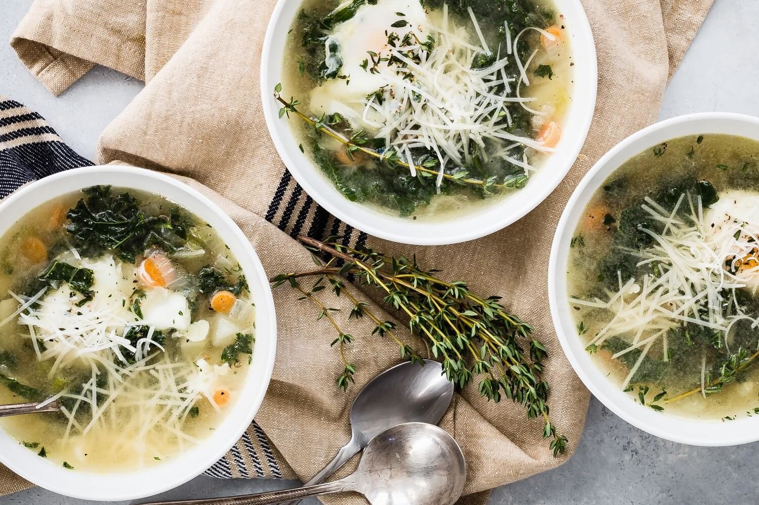 This winter kale and egg soup is perfect during the cold season and is vegetarian friendly. The soup is pictured with steamed kale, poached eggs, and parmesan cheese. | peteandgerrys.com 