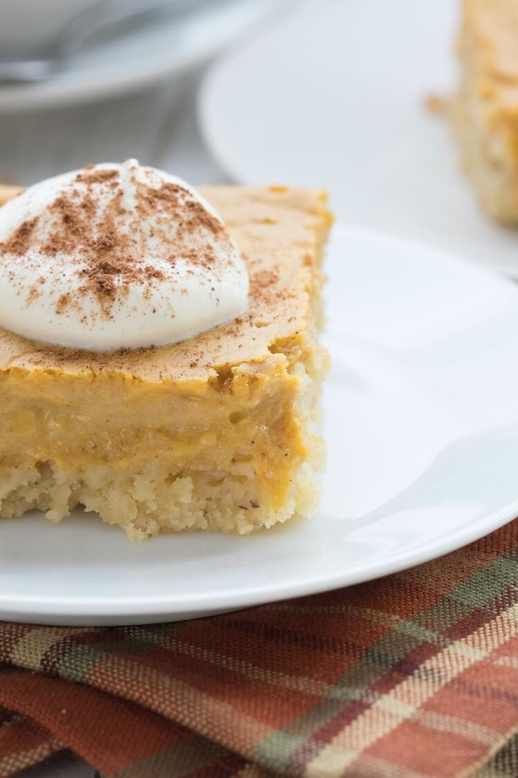 This keto pumpkin gooey butter cake is made with almond flour, organic eggs, cream cheese, and pumpkin puree. Pictured is the layered cake with the top layer very gooey from the bottom layers. | peteandgerrys.com