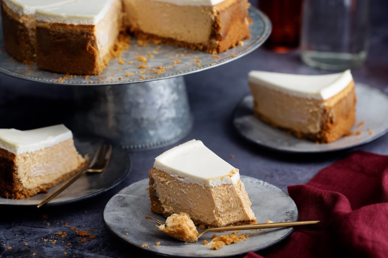 A smooth and silky pumpkin cheesecake recipe featuring a cinnamon ginger crust and creamy maple bourbon topping. | peteandgerrys.com