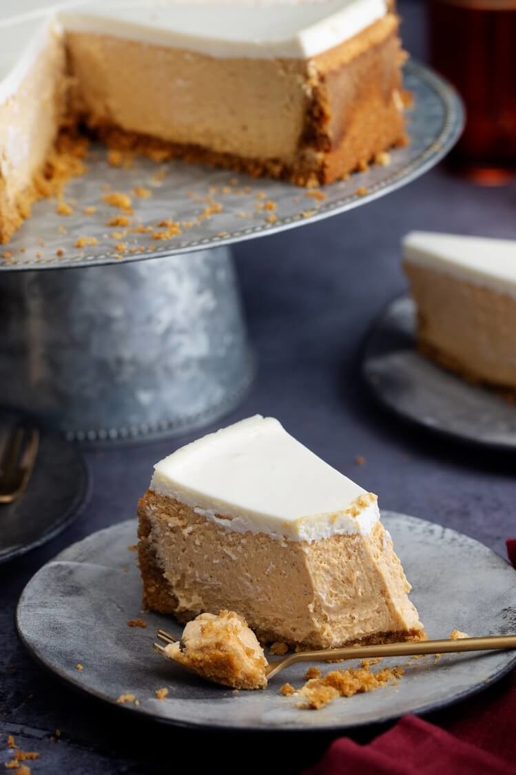 A smooth and silky pumpkin cheesecake recipe featuring a cinnamon ginger crust and creamy maple bourbon topping. | peteandgerrys.com