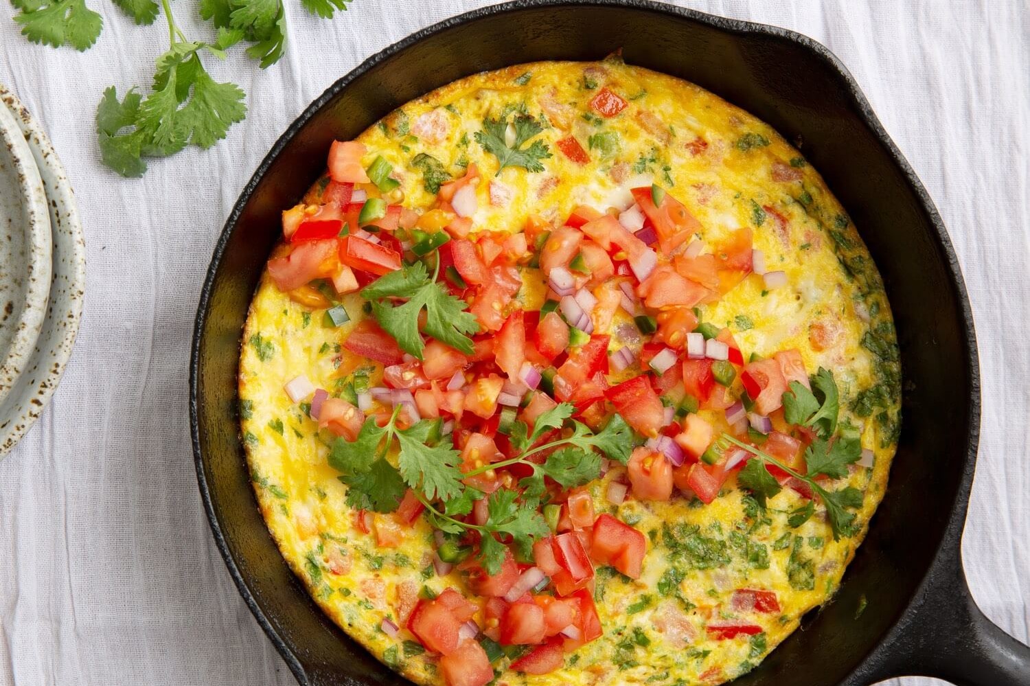 This Mexican frittata is made with bright orange organic eggs, jalapeño, cilantro, and fresh pico de Gallo. | peteandgerrys.com 