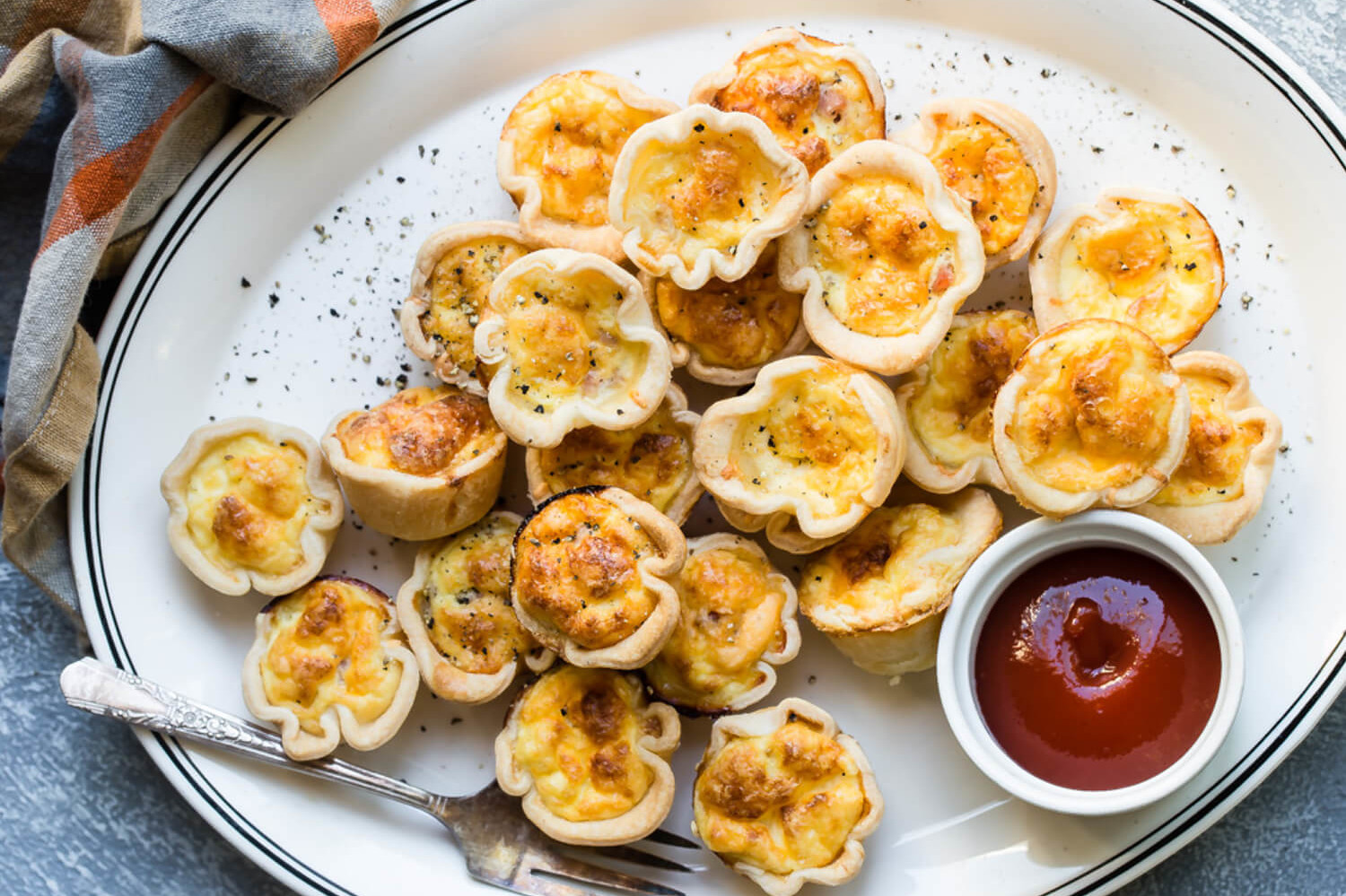 These mini cheese and ham quiches have an organic egg and cream filling with pieces of diced ham. The custard is wrapped in a golden and crispy phyllo wrap. | peteandgerrys.com 