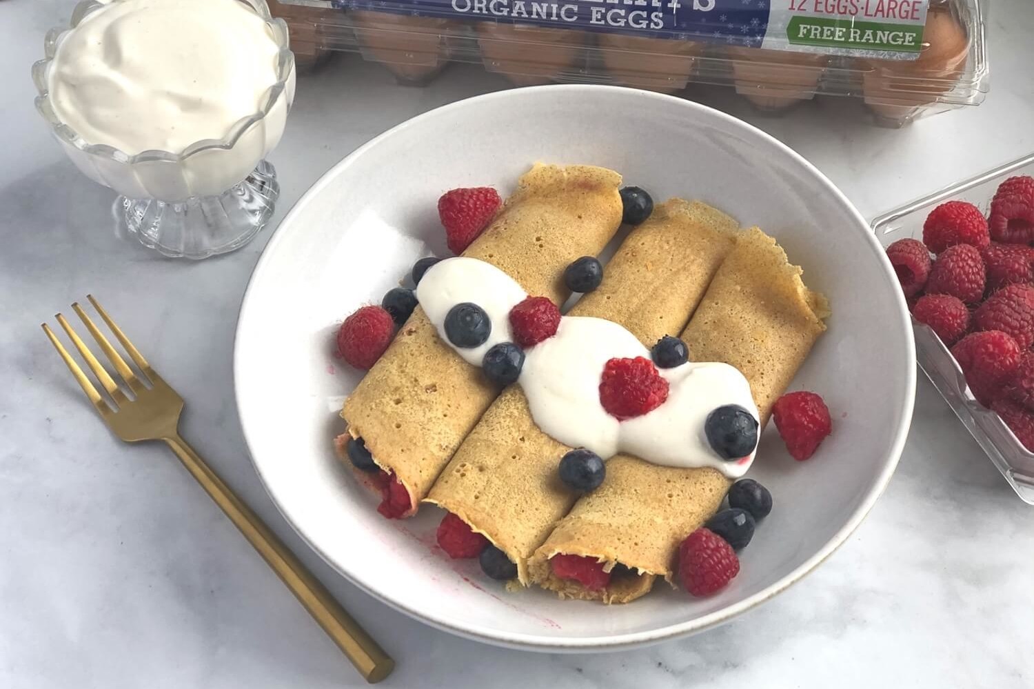 These Norwegian pancakes are a cross between French crepes and American pancakes. These pancakes are rolled with fresh berries and topped with a homemade cardamon whipped yogurt. | peteandgerrys.com 