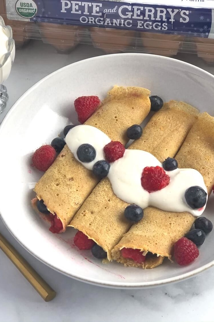 These Norwegian pancakes are a cross between French crepes and American pancakes. These pancakes are rolled with fresh berries and topped with a homemade cardamon whipped yogurt. | peteandgerrys.com 