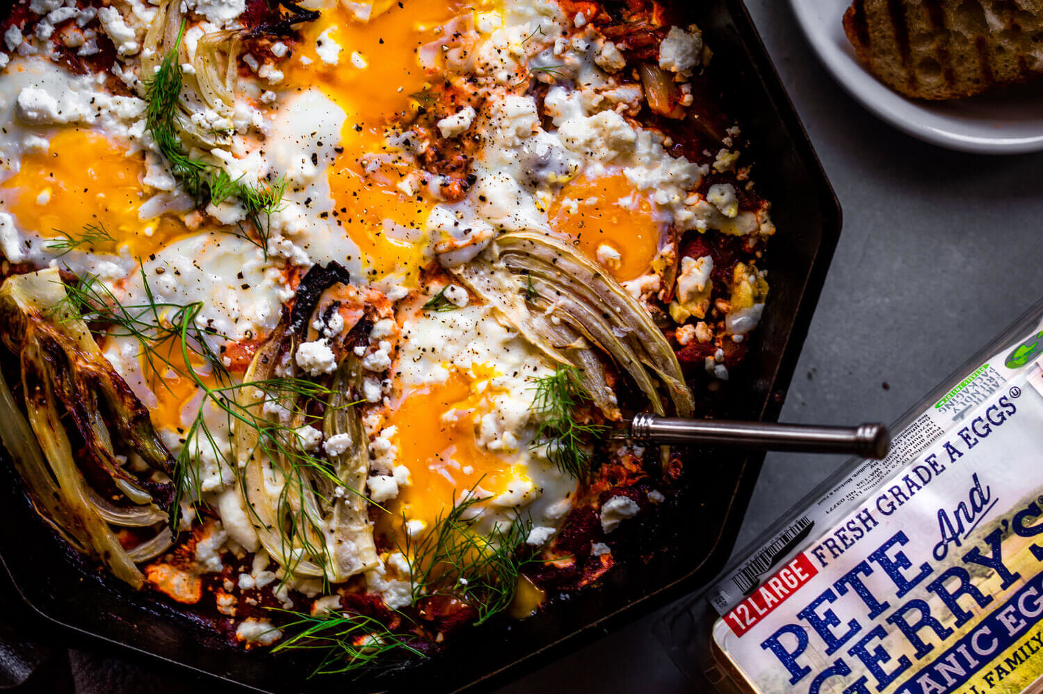 This recipe features fennel, plum tomatoes, feta cheese, and fresh parsley. This dish is topped with baked eggs. | peteandgerrys.com 