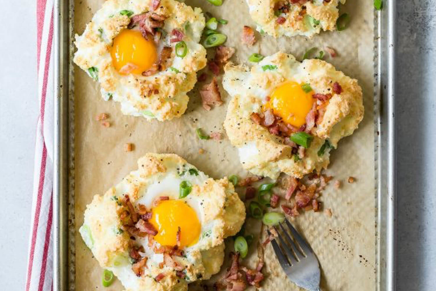 Cloud eggs flavored with Gruyère cheese, green onions, and bacon. Whipped egg whites are formed into nests on a baking sheet, then baked with yolks in the centers. | peteandgerrys.com 