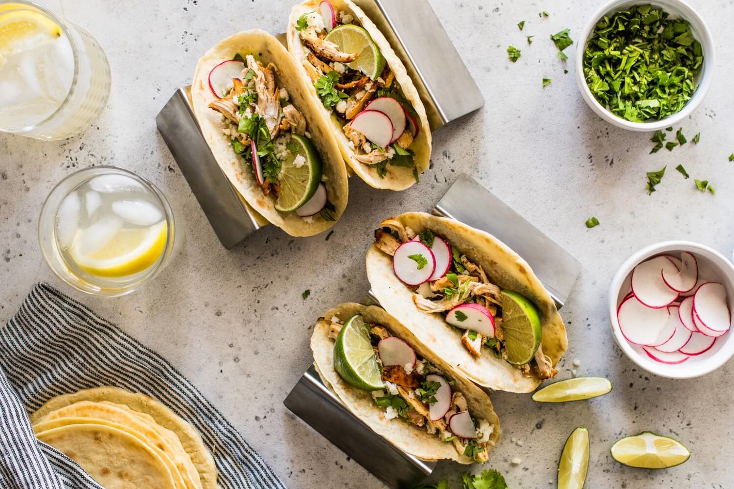 These paleo chicken tacos feature homemade paleo tortillas made with tapioca flour. The filling is chicken thighs mixed with queso fresco, cilantro, thinly sliced radishes, and lime wedges. | peteandgerrys.com 