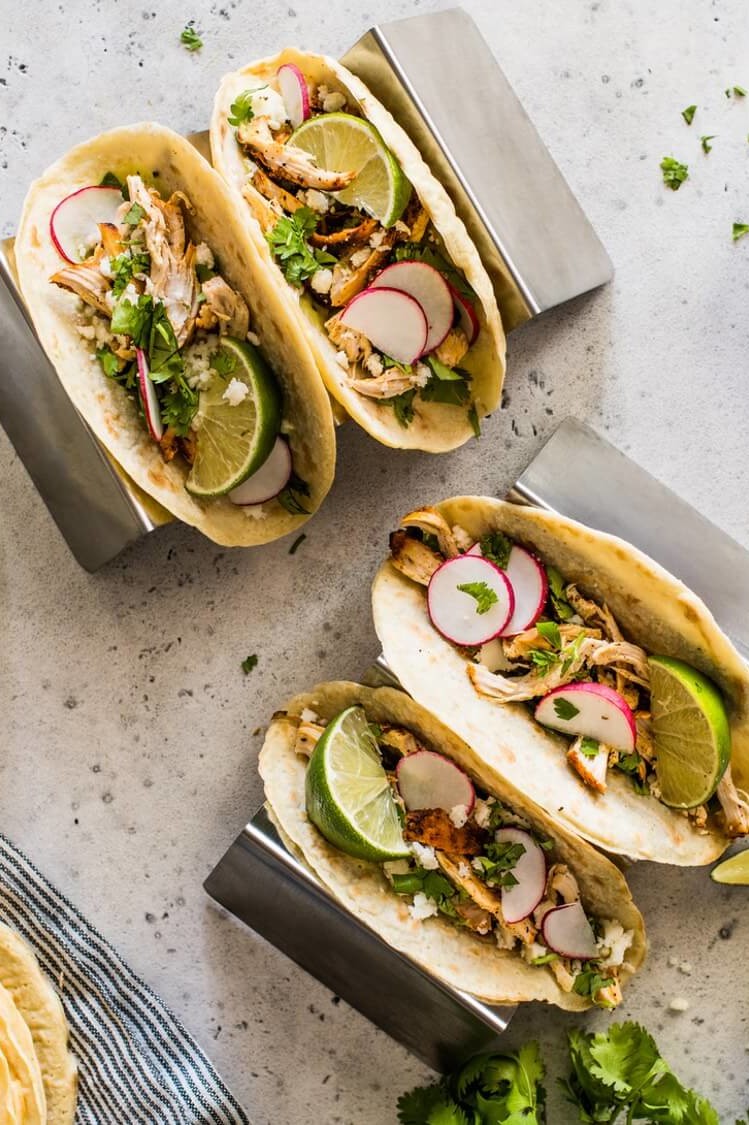 These paleo chicken tacos feature homemade paleo tortillas made with tapioca flour. The filling is chicken thighs mixed with queso fresco, cilantro, thinly sliced radishes, and lime wedges. | peteandgerrys.com 