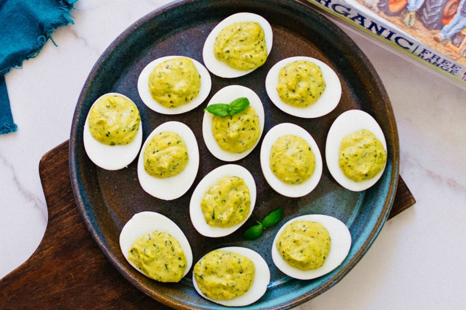 These paleo pesto deviled eggs are a fantastic innovation to the southern classic. The filling is made with a nut-free homemade pesto and topped with fresh basil. | peteandgerrys.com 