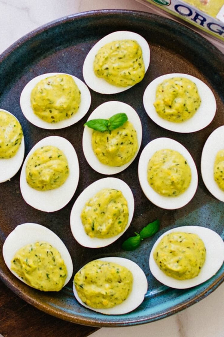 These paleo pesto deviled eggs are a fantastic innovation to the southern classic. The filling is made with a nut-free homemade pesto and topped with fresh basil. | peteandgerrys.com 