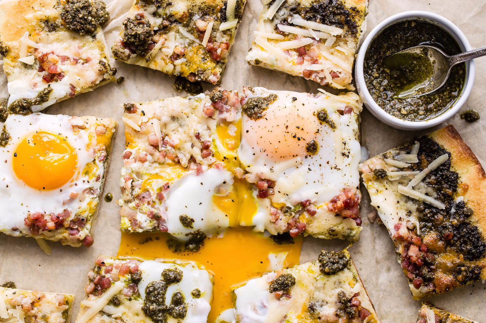 The pancetta egg flatbread features crispy and delicious pancetta, green pesto, and runny fried organic eggs. | peteandgerrys.com 