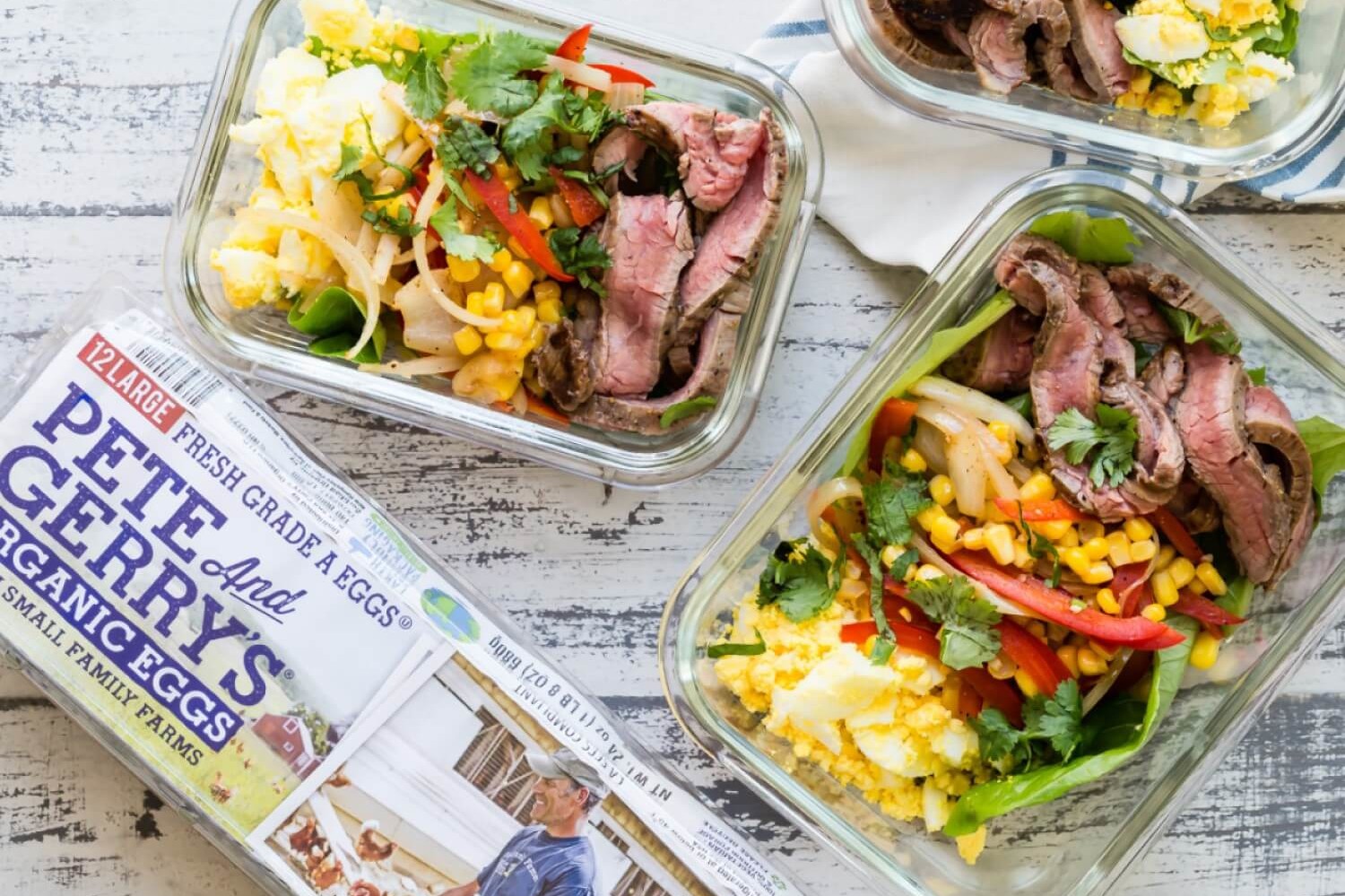 These low-carb fajita bowls are great for a make-ahead lunch or dinner. These bowls feature flank steak, bell peppers, cilantro, crumbled organic eggs, and sweet corn. | peteandgerrys.com 