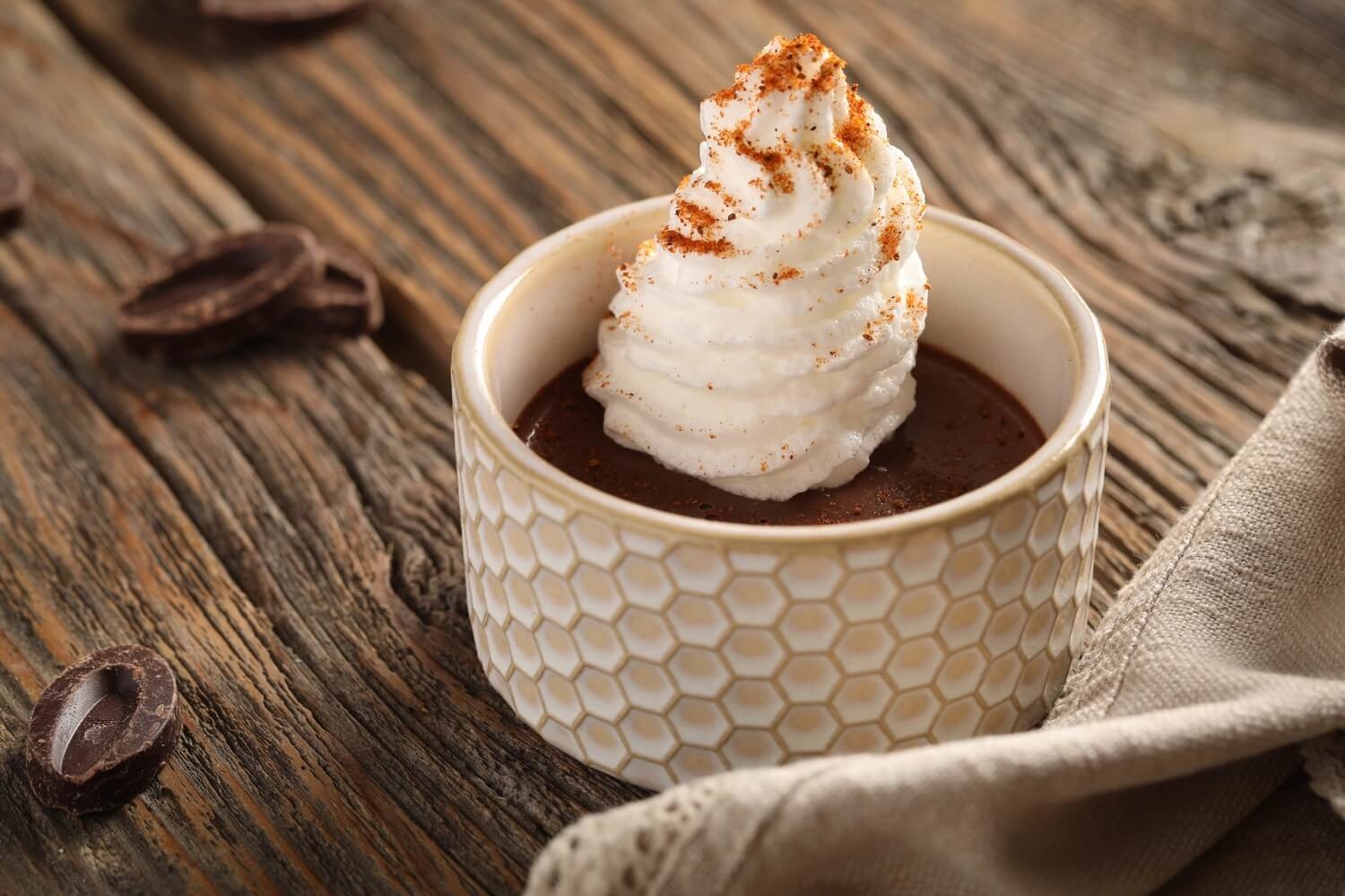 Recipe for chocolate pots de crème served in individual ramekins. This rich custard is made with egg yolks, heavy cream, sugar, and dark chocolate, then topped with piped meringue and dusted with an optional pinch of Old Bay seasoning. | peteandgerrys.com 