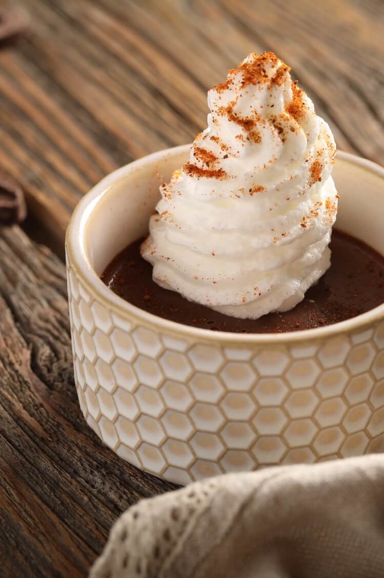 Recipe for chocolate pots de crème served in individual ramekins. This rich custard is made with egg yolks, heavy cream, sugar, and dark chocolate, then topped with piped meringue and dusted with an optional pinch of Old Bay seasoning. | peteandgerrys.com 