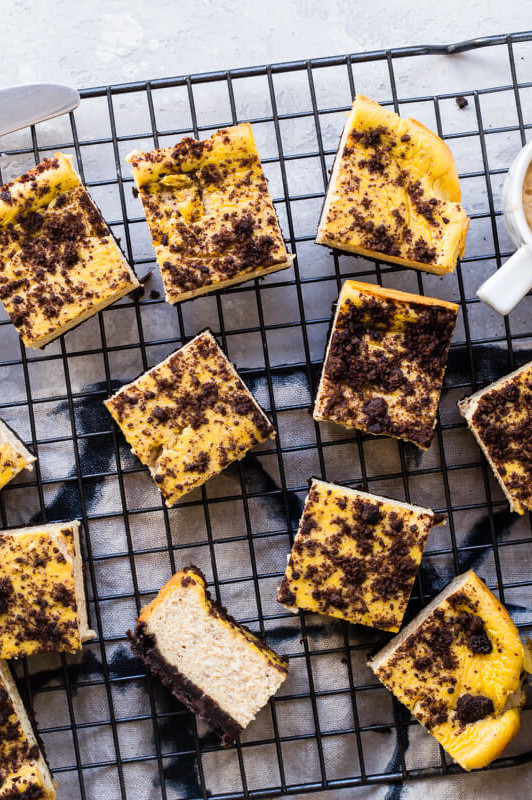 These pumpkin cheesecake bars are a perfect mix of fall spice and chocolate cookie crumbles. This recipe features a chocolate crumb base and filled with a pumpkin purée cream cheese mix. | peteandgerrys.com