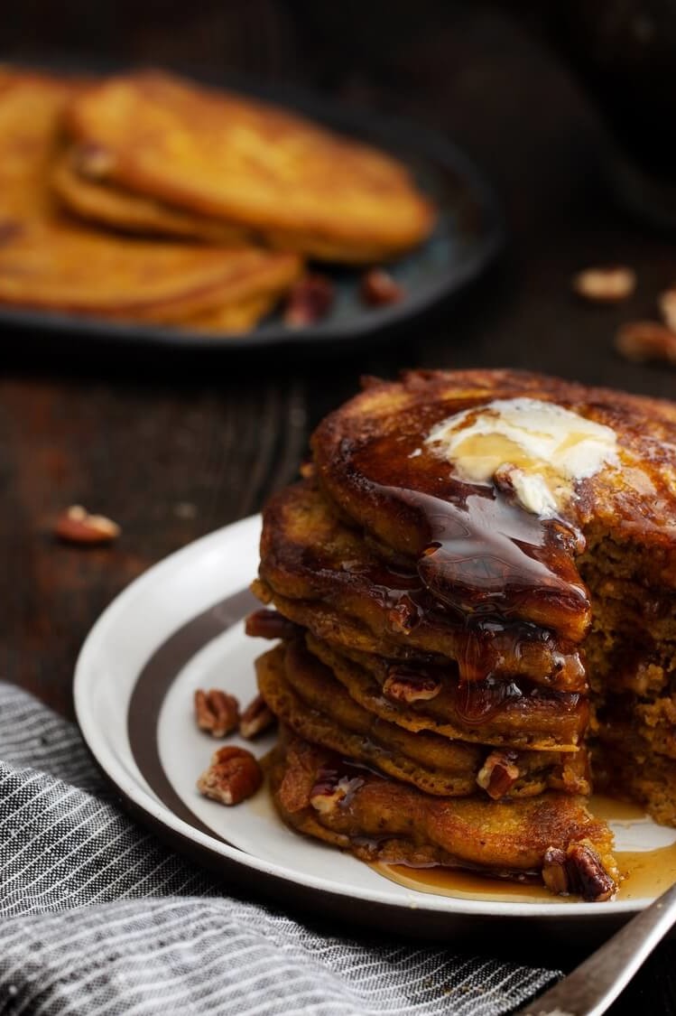 These pumpkin pecan pancakes are moist on the inside and cooked until golden on the outside. Pictured is maple syrup and Nellie's butter in the top cross-section. | peteandgerrys.com 