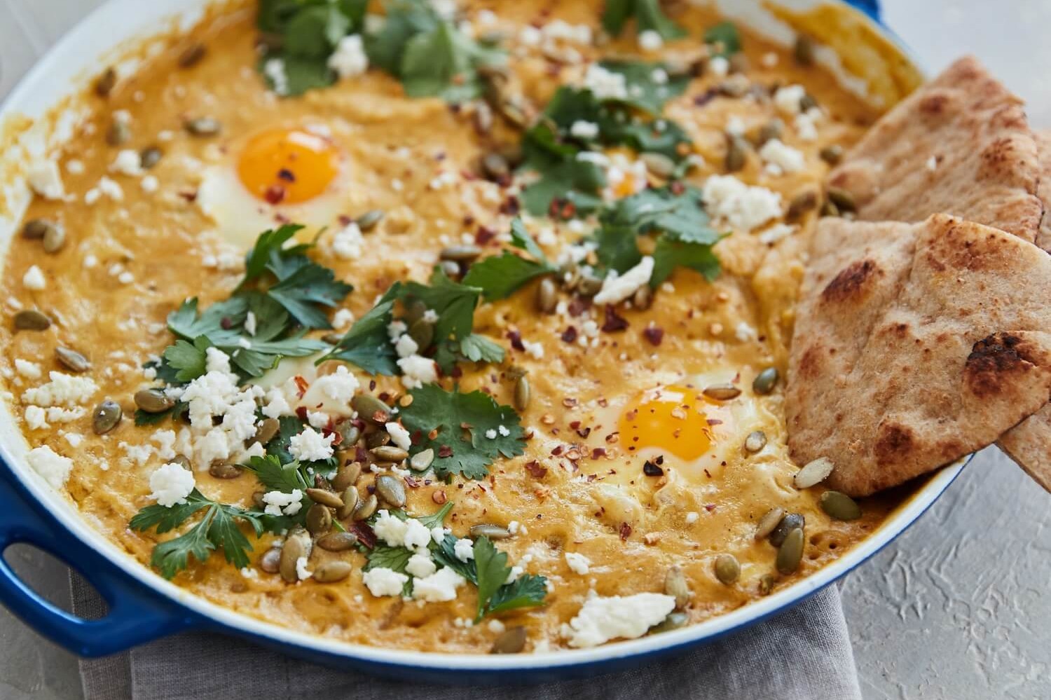 This pumpkin shakshuka is topped with queso fresco or feta cheese, and fresh parsley. This dish is perfect with fresh pita bread. | peteandgerrys.com 